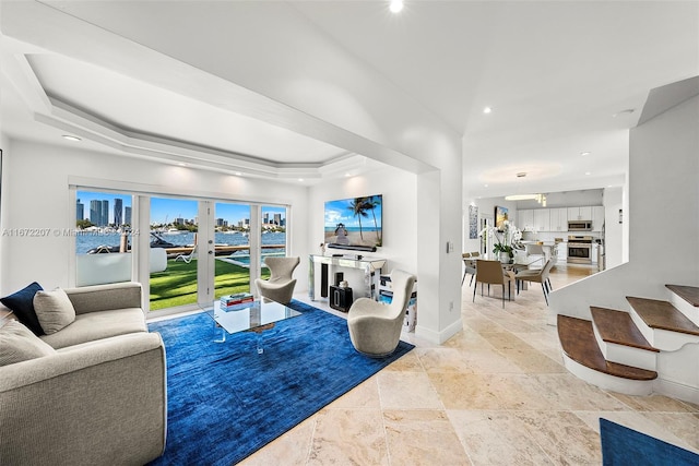 living room featuring french doors and a tray ceiling