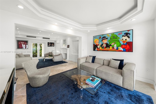 living room featuring french doors and a tray ceiling