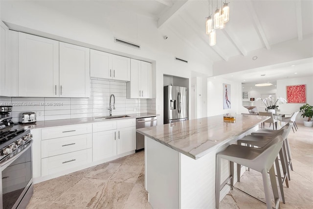 kitchen featuring a breakfast bar, sink, light stone countertops, beamed ceiling, and stainless steel appliances