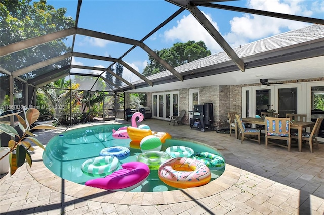 view of swimming pool featuring a patio area, french doors, glass enclosure, and ceiling fan