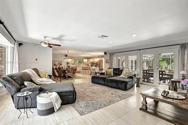 tiled living room featuring ceiling fan and french doors