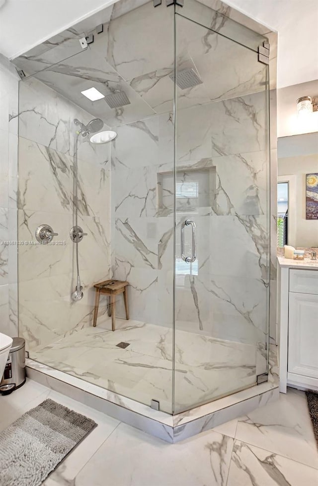 bathroom with a shower with door and vanity