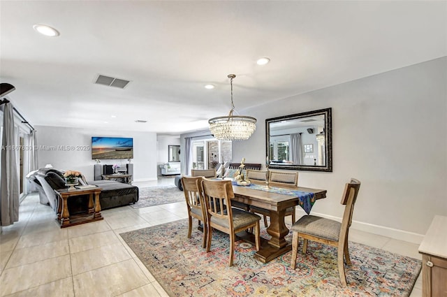 dining room with a chandelier and light tile patterned floors