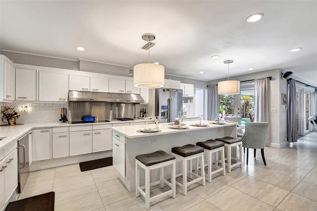 kitchen with white cabinetry, high end fridge, decorative backsplash, a kitchen island, and decorative light fixtures