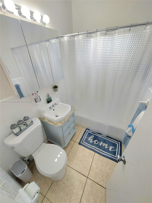 bathroom with vanity, toilet, tile walls, and tile patterned flooring