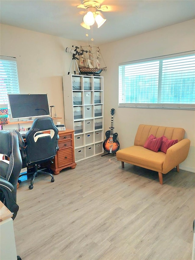 home office with light hardwood / wood-style floors and ceiling fan