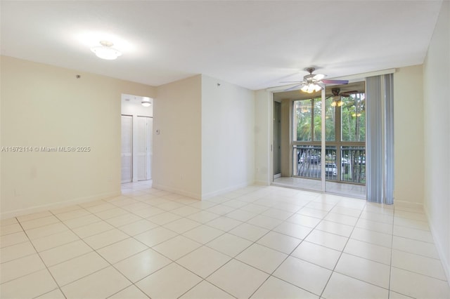 spare room with light tile patterned floors, ceiling fan, and baseboards