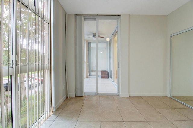 hallway with light tile patterned floors and baseboards