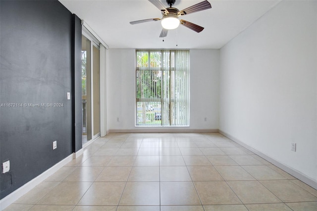 unfurnished room with light tile patterned flooring, floor to ceiling windows, and ceiling fan