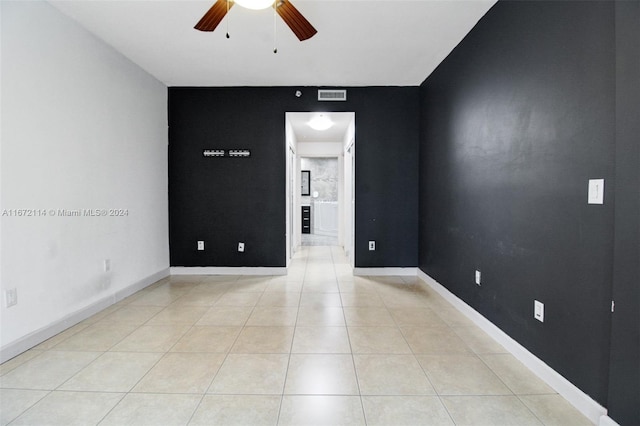 tiled empty room featuring ceiling fan