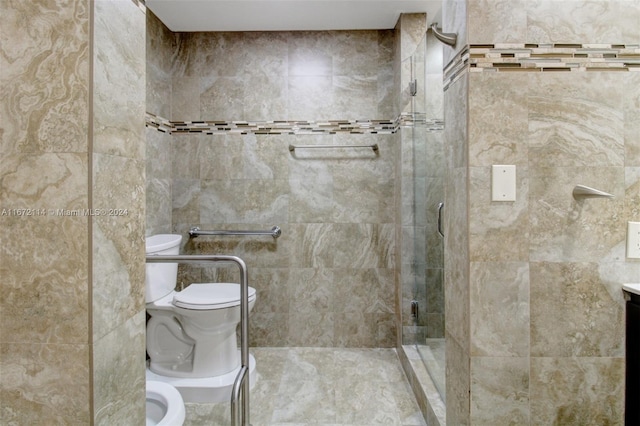 bathroom with vanity, a shower with shower door, a bidet, and toilet