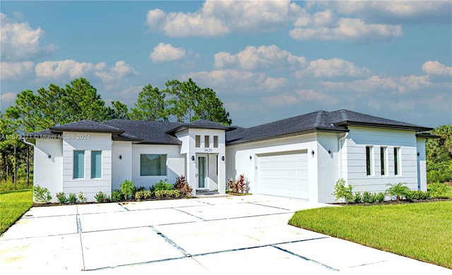 prairie-style house featuring a garage and a front lawn