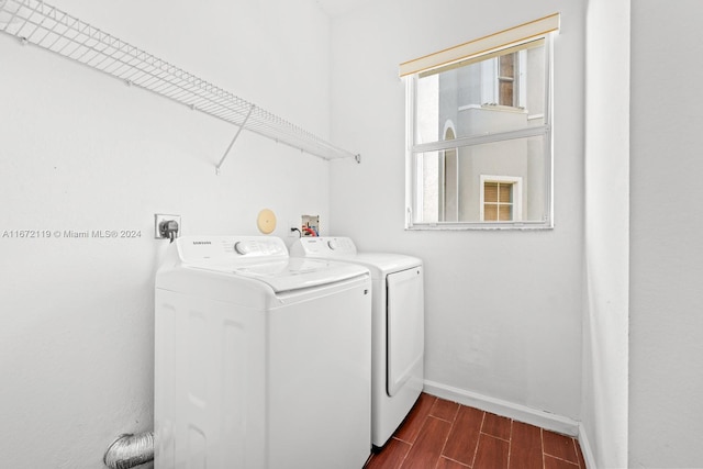 clothes washing area featuring washing machine and dryer and dark hardwood / wood-style floors