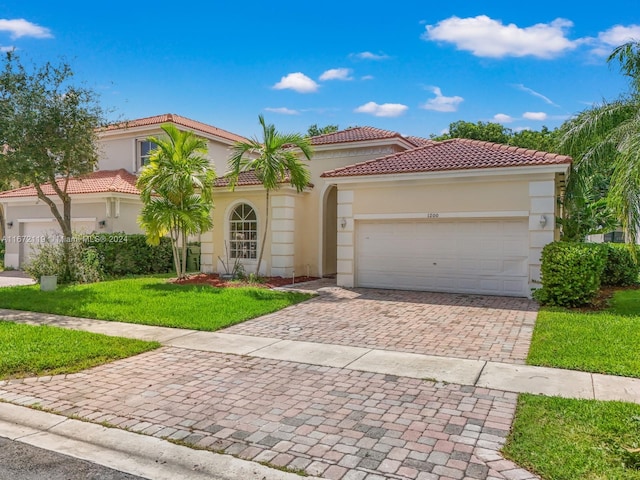 mediterranean / spanish-style house featuring a front lawn and a garage