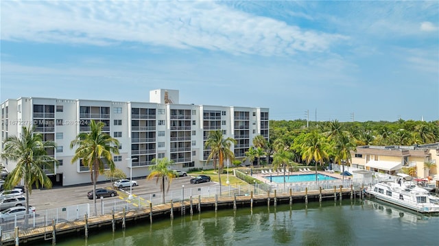 view of property with a community pool and a water view