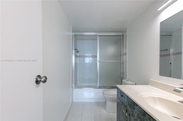 full bathroom with bath / shower combo with glass door, vanity, toilet, and tile patterned floors