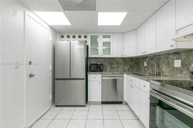 kitchen with white cabinets, appliances with stainless steel finishes, a paneled ceiling, and sink