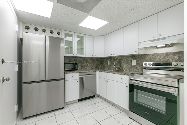 kitchen featuring sink, white cabinets, a drop ceiling, appliances with stainless steel finishes, and light tile patterned floors