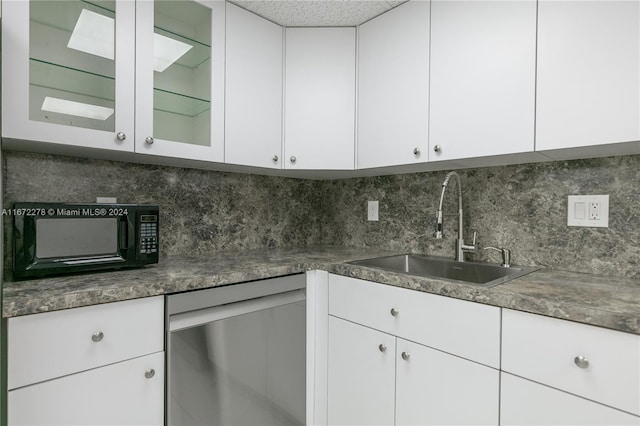 kitchen with white cabinets, dishwasher, and sink