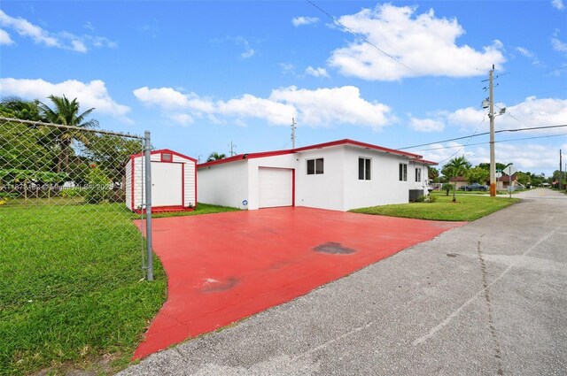 view of side of home featuring a yard and a shed