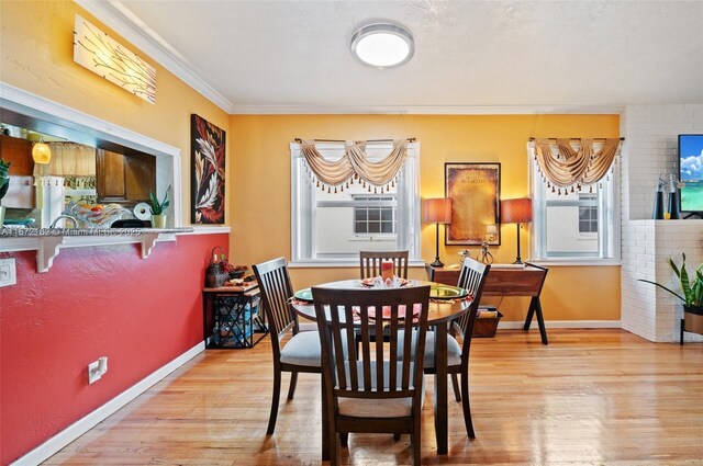 living room featuring a fireplace, light hardwood / wood-style flooring, ceiling fan, and crown molding