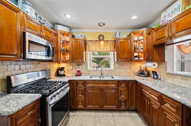 kitchen featuring kitchen peninsula, washing machine and dryer, sink, and appliances with stainless steel finishes