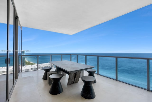 balcony with a water view and a view of the beach