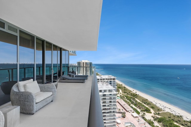 balcony featuring a beach view and a water view