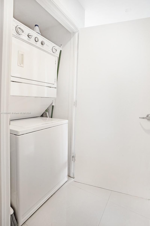 laundry area featuring stacked washer and dryer and light tile patterned floors