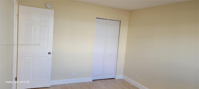 unfurnished bedroom with a closet and light hardwood / wood-style flooring