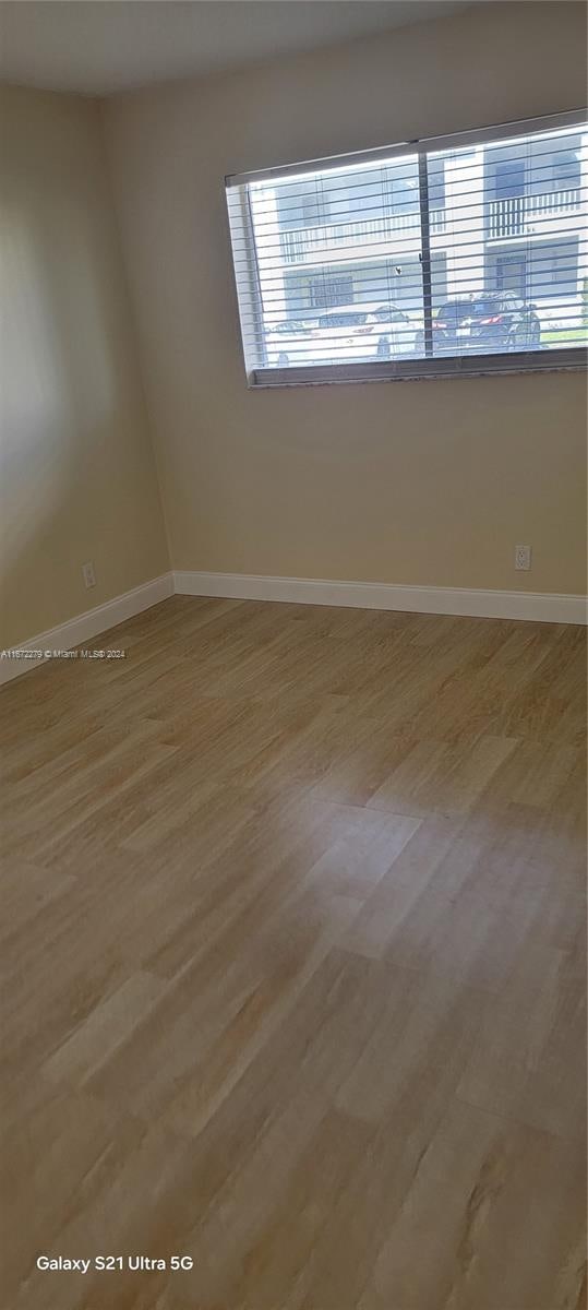 unfurnished room with hardwood / wood-style flooring