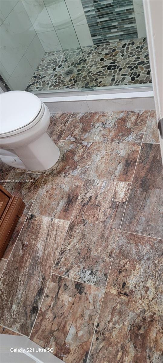 bathroom featuring a shower and toilet