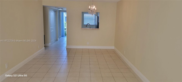 spare room with a notable chandelier, light tile patterned floors, and sink