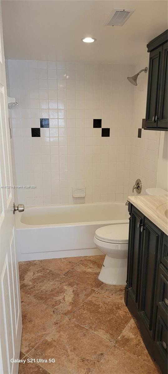 full bathroom featuring vanity, toilet, and tiled shower / bath