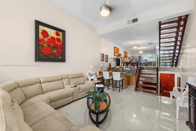 living room with ceiling fan with notable chandelier