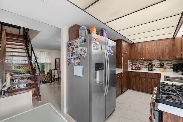 kitchen with dark brown cabinetry, appliances with stainless steel finishes, and backsplash