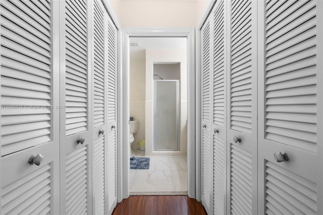 corridor featuring tile walls and dark hardwood / wood-style flooring