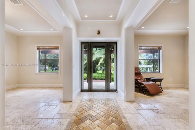 entrance foyer featuring ornamental molding and plenty of natural light