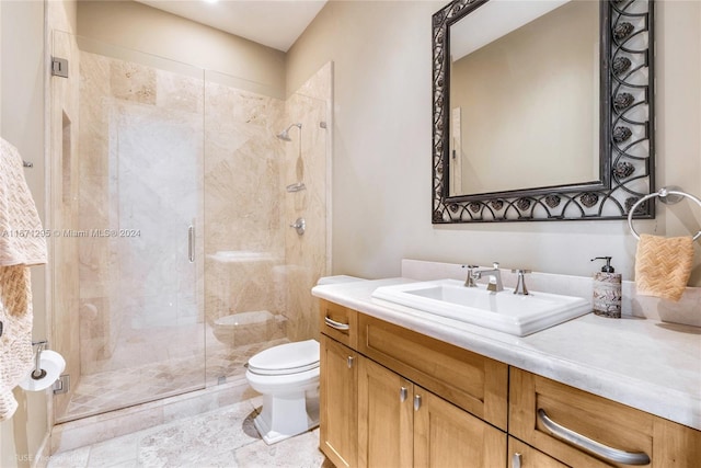 bathroom with vanity, toilet, and a shower with door