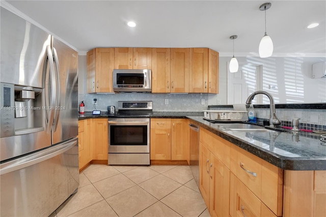 kitchen with hanging light fixtures, backsplash, appliances with stainless steel finishes, light tile patterned floors, and sink