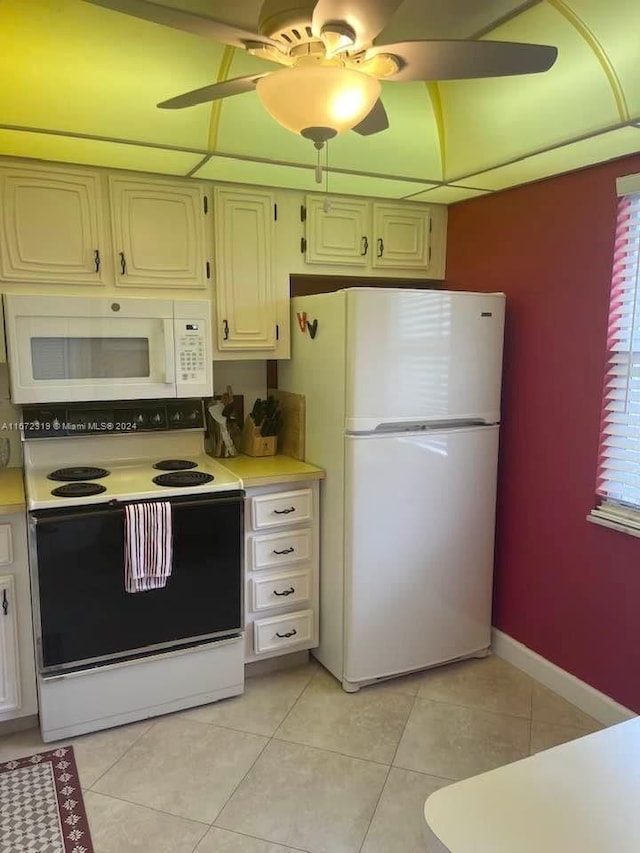 kitchen with light tile patterned floors, white appliances, and ceiling fan