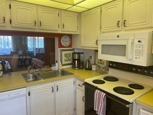 kitchen with white appliances, a wealth of natural light, and sink