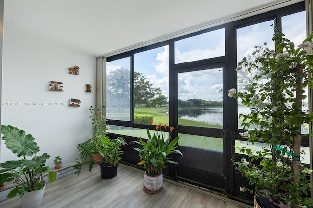 sunroom featuring a water view