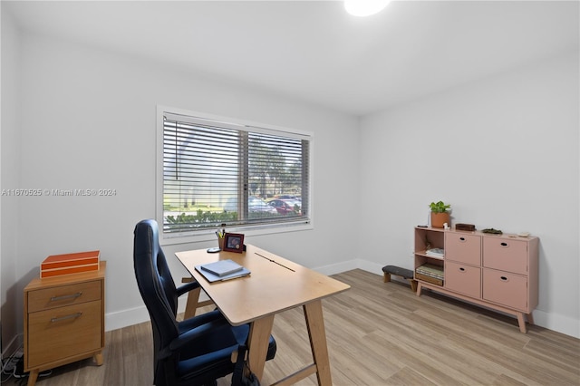 home office with light hardwood / wood-style floors