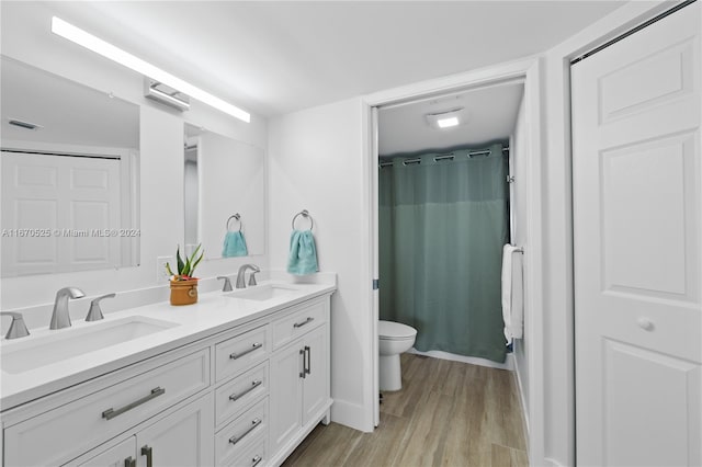 bathroom with hardwood / wood-style flooring, vanity, toilet, and a shower with curtain