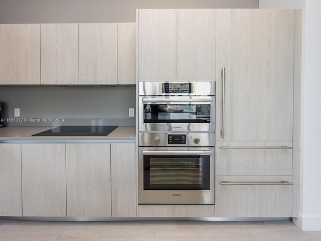 kitchen with stainless steel double oven, black electric stovetop, and light brown cabinetry