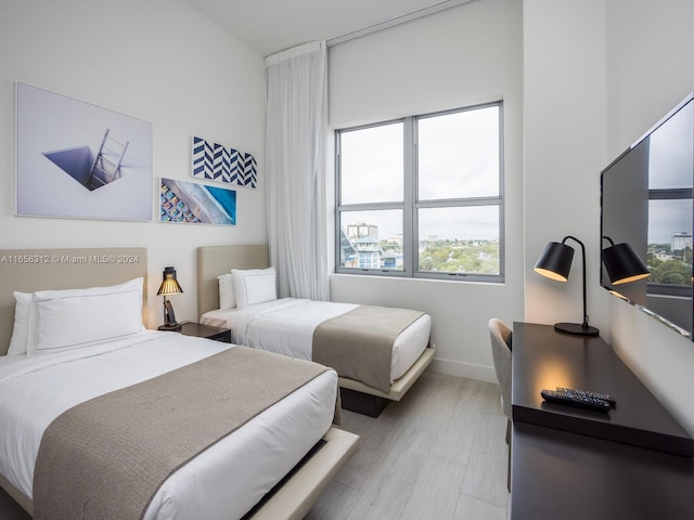 bedroom with light hardwood / wood-style floors and multiple windows