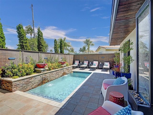 view of pool with outdoor lounge area, a patio, and pool water feature