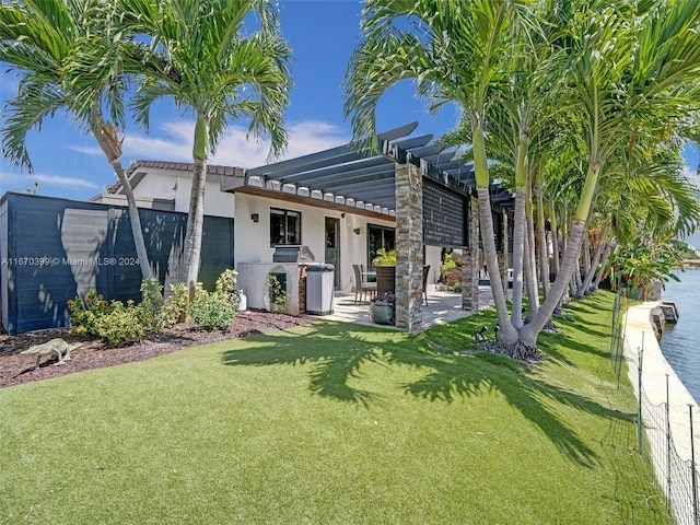 back of property featuring a lawn, a pergola, and a patio area