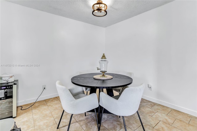 tiled dining space featuring a textured ceiling